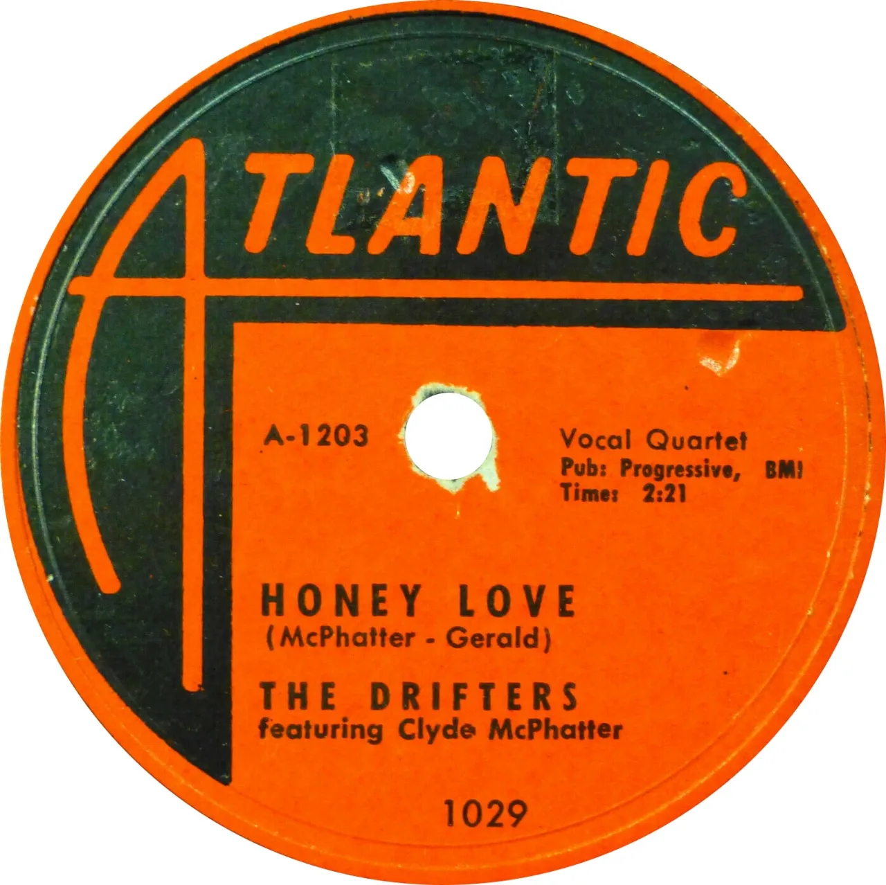 An orange and black Atlantic Records label for “Honey Love” by the Drifters featuring Clyde McPhatter, with the numbers A-1203 and 1029 printed on it