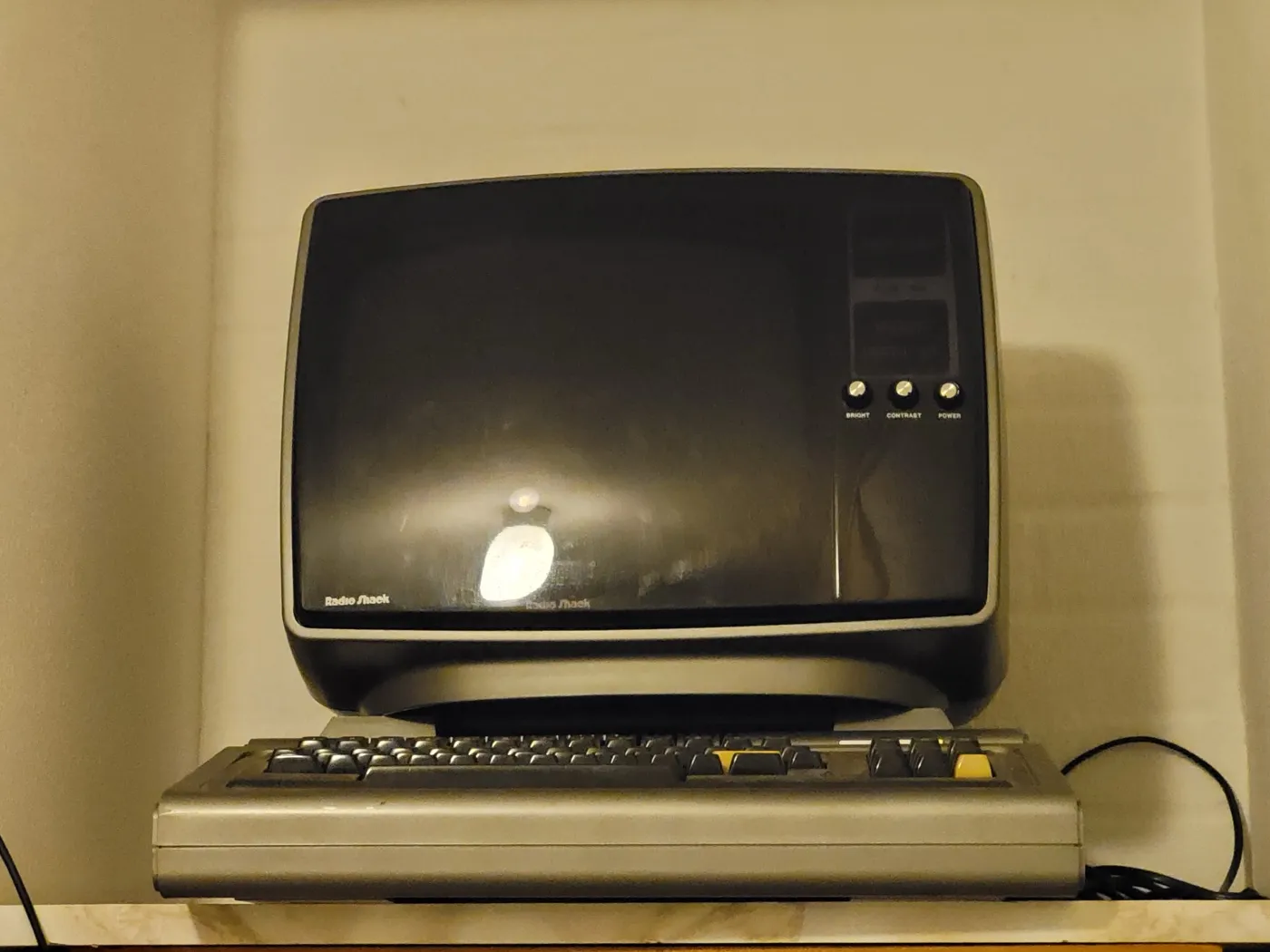 A TRS-80 Model I computer: a gray keyboard unit with a dark-screened Radio Shack video monitor sitting on top of it